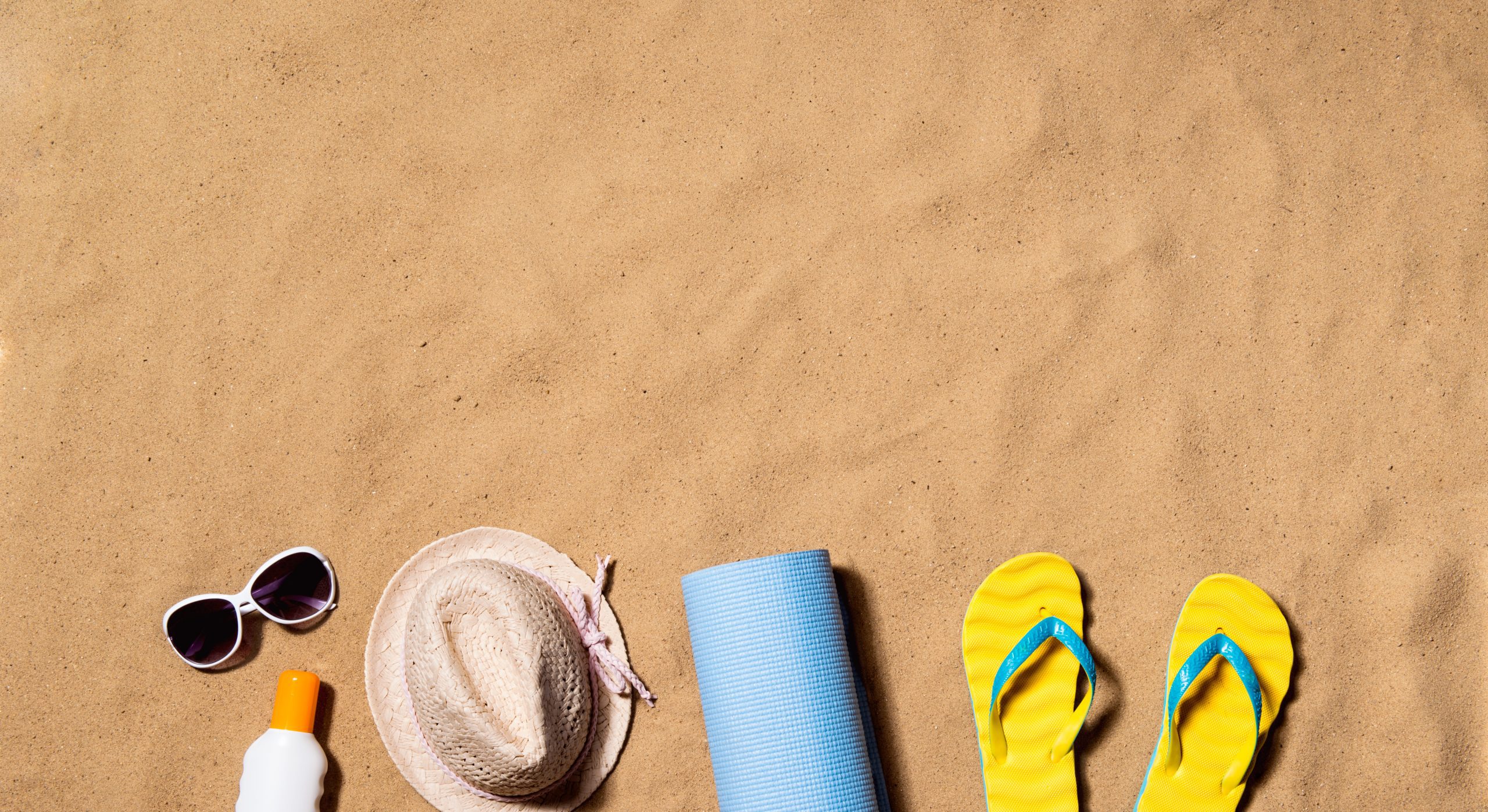 graphicstock summer vacation composition with pair of yellow flip flop sandals hat sunglasses sun cream and other stuff on a beach sand background studio shot flat lay copy space SdfbicUfZ scaled