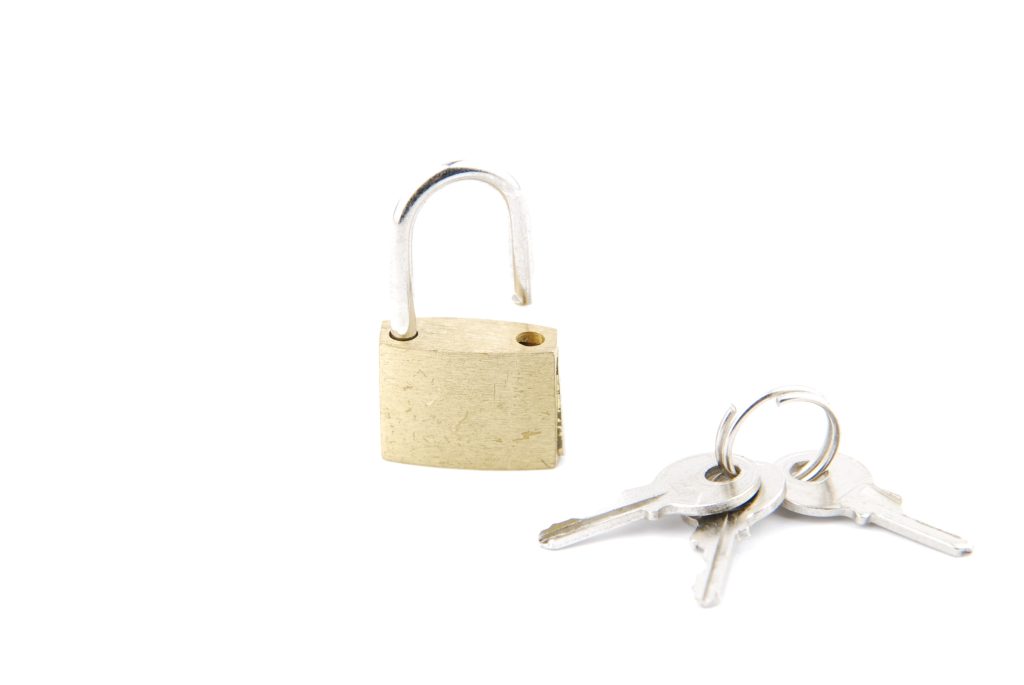 golden open padlock with keys on white QywamN