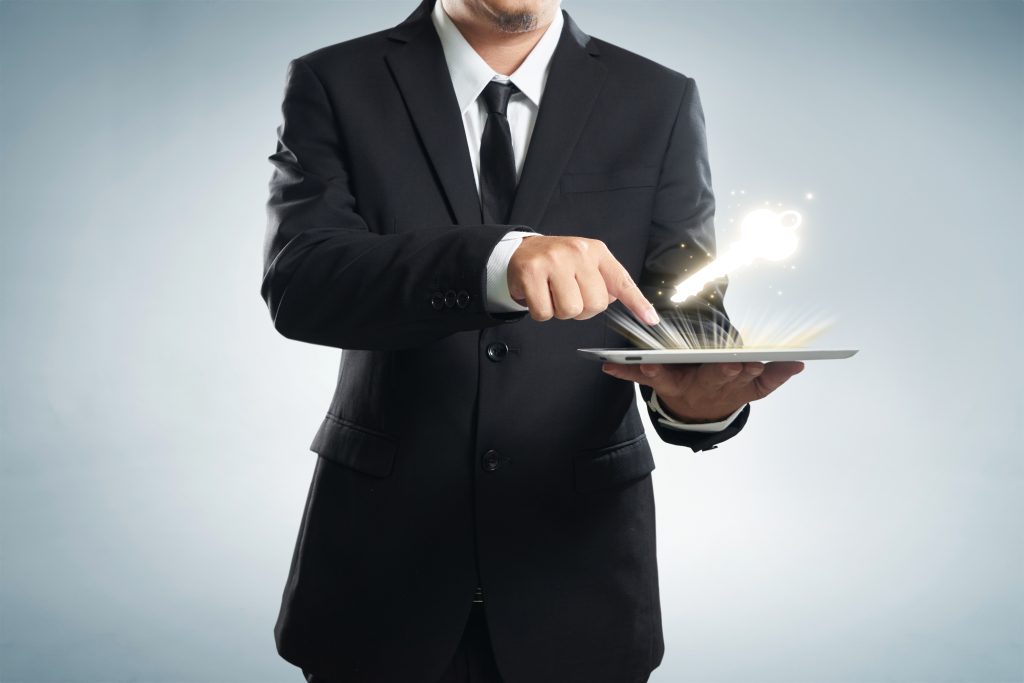 graphicstock successful young businessman shows the screen of the tablet with key to success symbo SO4ZYwowxjx