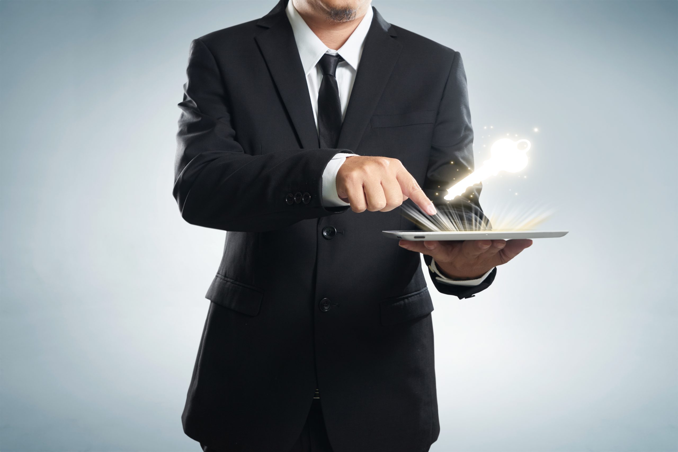 graphicstock successful young businessman shows the screen of the tablet with key to success symbo SO4ZYwowxjx scaled