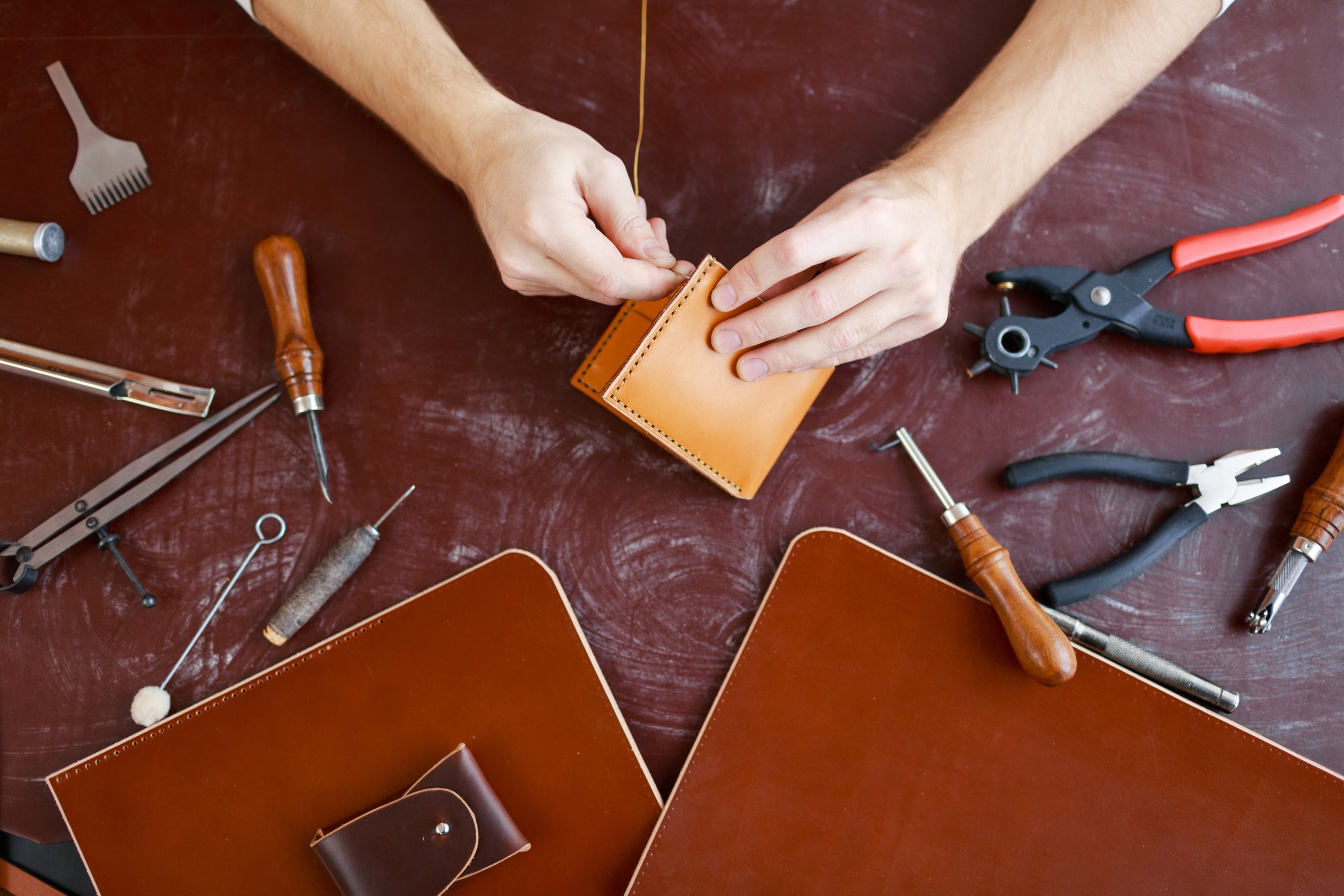 storyblocks human hands using handtool while producing leather item HhgbAurkkf scaled